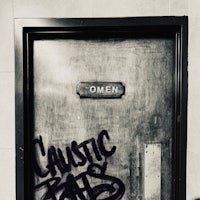 a bathroom door with graffiti on it